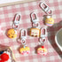 Set of cute keychains shaped like cartoon pastries on a pink checkered background