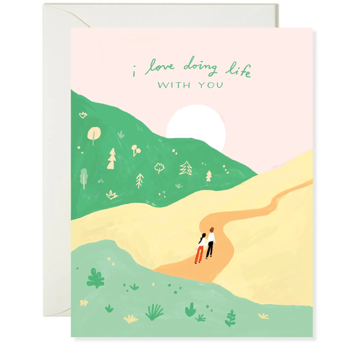 A folded greeting card with an illustration of a pathway in a natural setting, with text that reads 'I love doing life with you' and a sun and moon in the background.