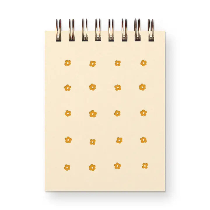 Small notebook with gold floral patterns on a white background