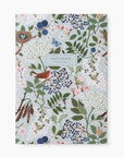 A notebook with a detailed botanical and bird pattern on a pale blue-gray background, featuring green leaves, white flowers, blue berries, pink blossoms, and a red bird. The center label reads 'NOTEBOOK' with '180 blank pages' underneath.
