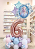 Decorative balloons with a number '6' and a character in a store setting