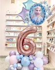 Decorative balloons with a number '6' and a character in a store setting