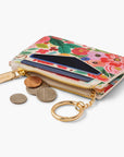 Side view of the floral card wallet with the zipper unzipped and coin change sitting outside of it.
