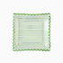A green striped scalloped paper plate with a foil pattern.