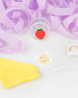 An unravelled surprise ball with small favors inside like a tattoo, sticker, and joke