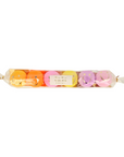 A set of 6 happy face surprise balls wrapped in a clear plastic shaped like a long candy