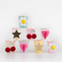 A set of colorful 3D honeycomb design cups in various pastel colors, each adorned with different happy-themed decorations such as flowers, hearts, and stars.