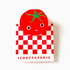 A clear acrylic clip with a decorative tomato design on the top, presented against a red and white checkered background with the text 'ILOOTPAPERIE'.