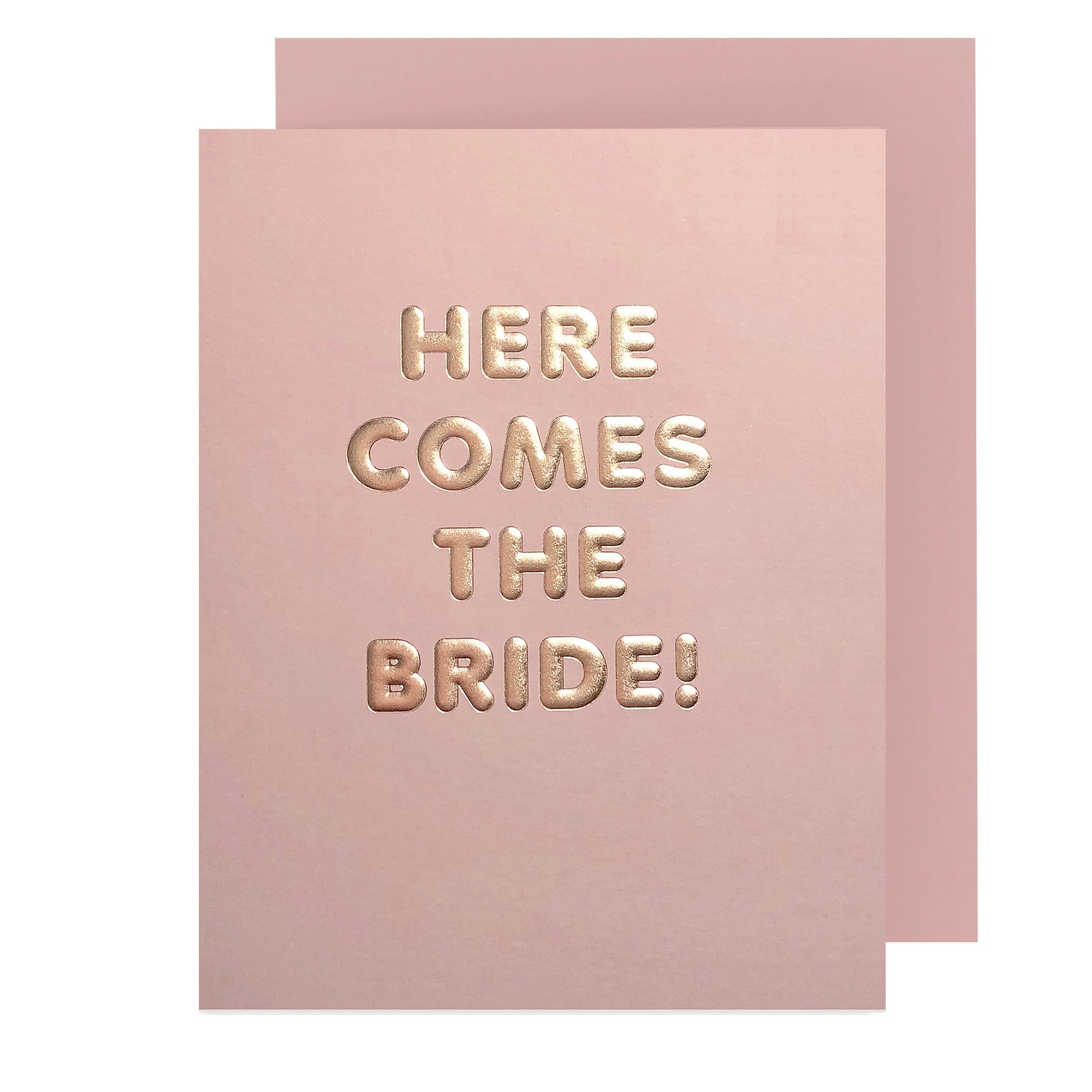 Pink greeting card that had gold text reading "here comes the bride!"