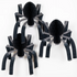 Three black paper spiders on a white background