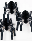Three black paper spiders on a white background