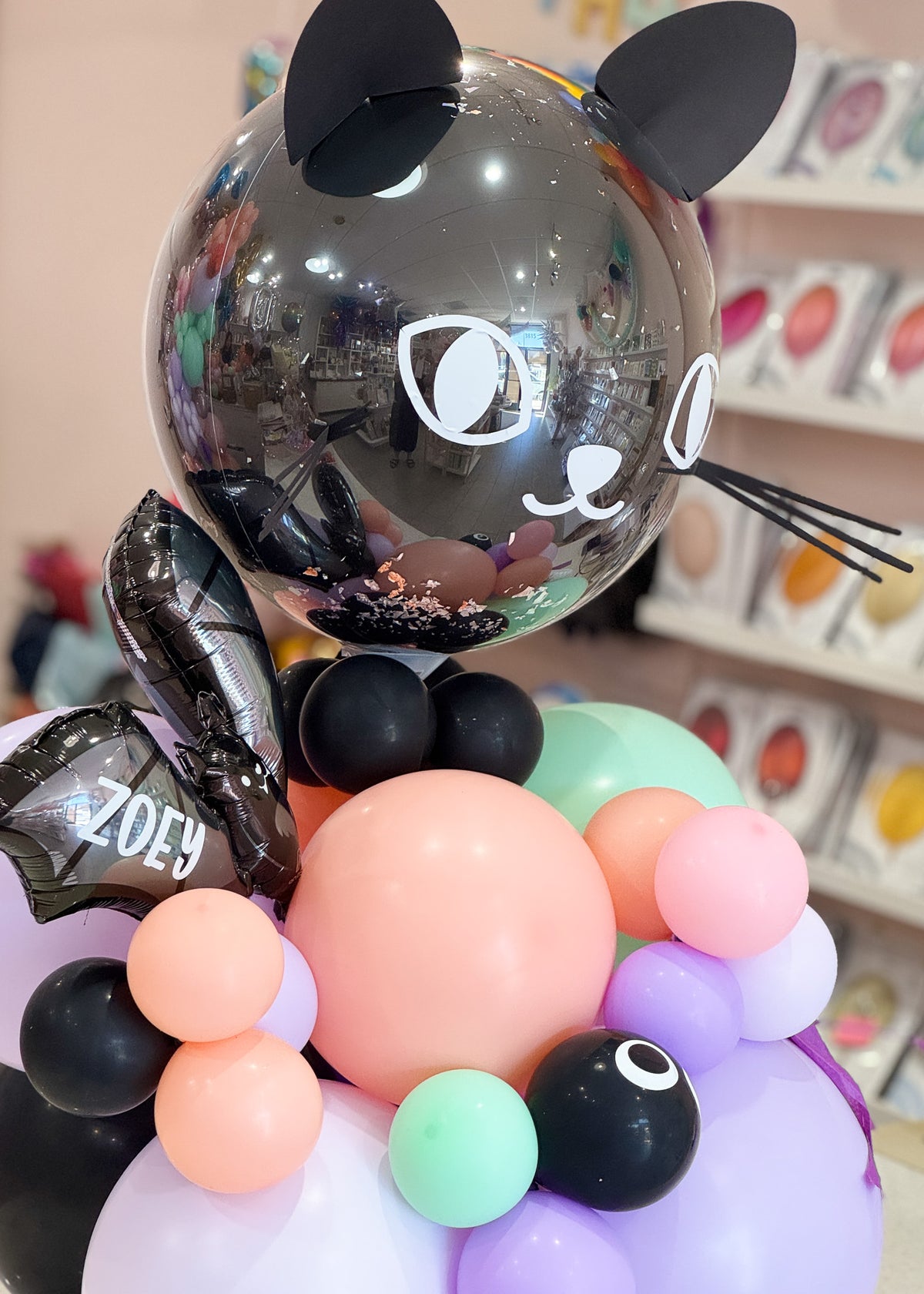 Close up view of the balloons with a personalized name on the halloween bat balloon