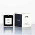 Black candle with white label and 'EMME' branding next to its box packaging on a white background