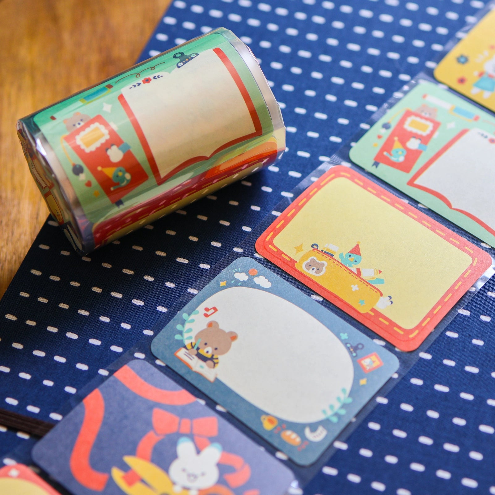 Roll of colorful stationery with various designs on a blue polka dot surface