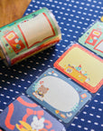 Roll of colorful stationery with various designs on a blue polka dot surface