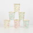 A set of four cups with floral designs in pastel colors and gold foil details, stacked together.