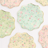 A set of eight round side plates with floral designs and gold foil scalloped borders, assorted in pastel colors.
