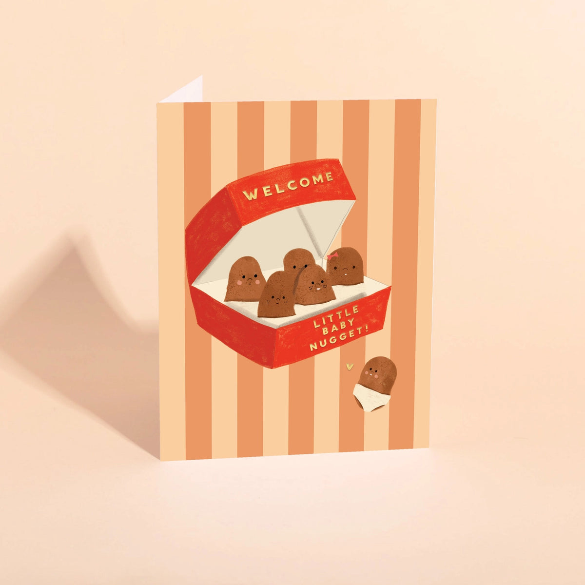 striped card featuring nuggets in a red box with text "welcome little baby nugget!" on pink background