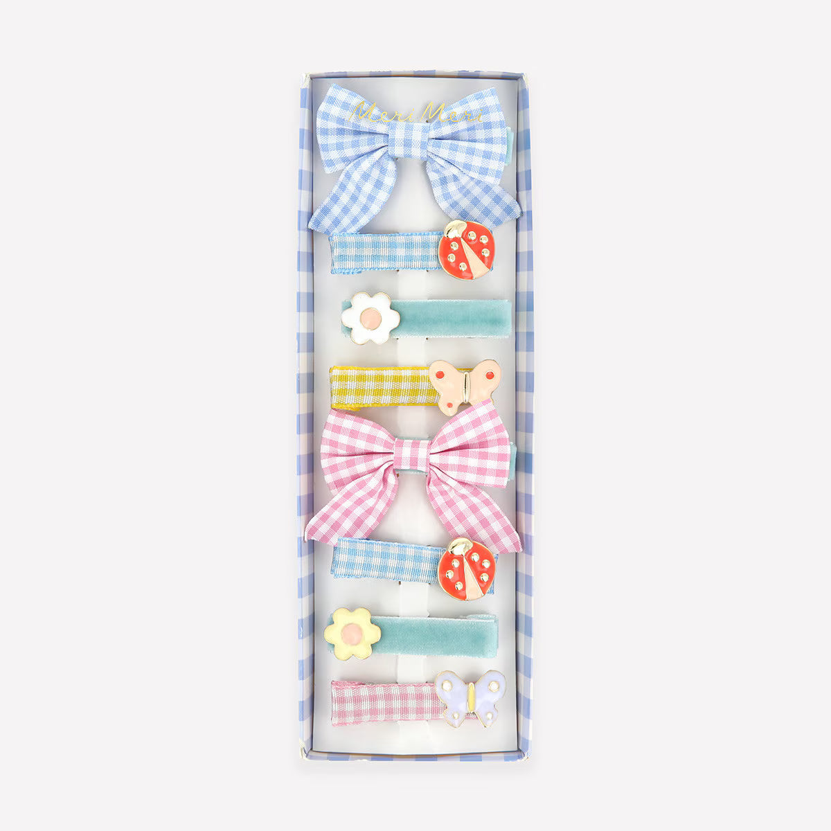 Set of colorful bows and spring icon hair clips in a box on a white background