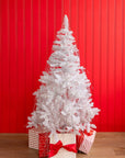 A white christmas tree with silver tinsel draped throughout, wrapped red and white presents underneath the tree and a red paneled wall