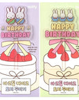 A cake topped with a Miffy-themed topper, featuring cartoon-style rabbit characters and birthday greetings.