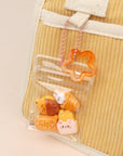 Clear plastic bag with small animal-shaped items attached to a beige textured surface.