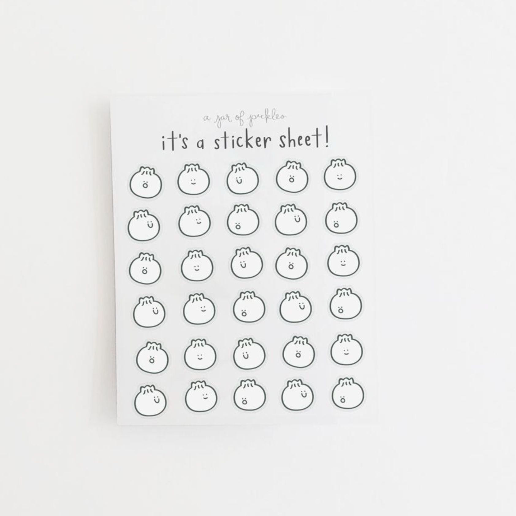 A sticker sheet with a pattern of dumplings, with the text 'It's a sticker sheet!' at the top.