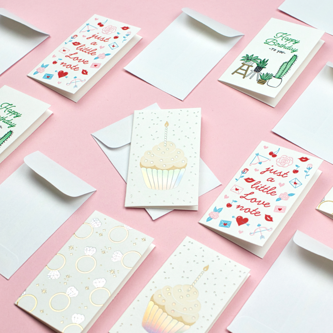 A variety of mini note cards on pink background
