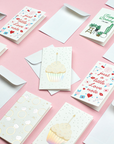 A variety of mini note cards on pink background