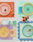 Rainbow table setting with placemats, paper plates and napkins.