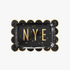 A black scalloped plate with gold stars and the word 'NYE' in the center, designed for party use.