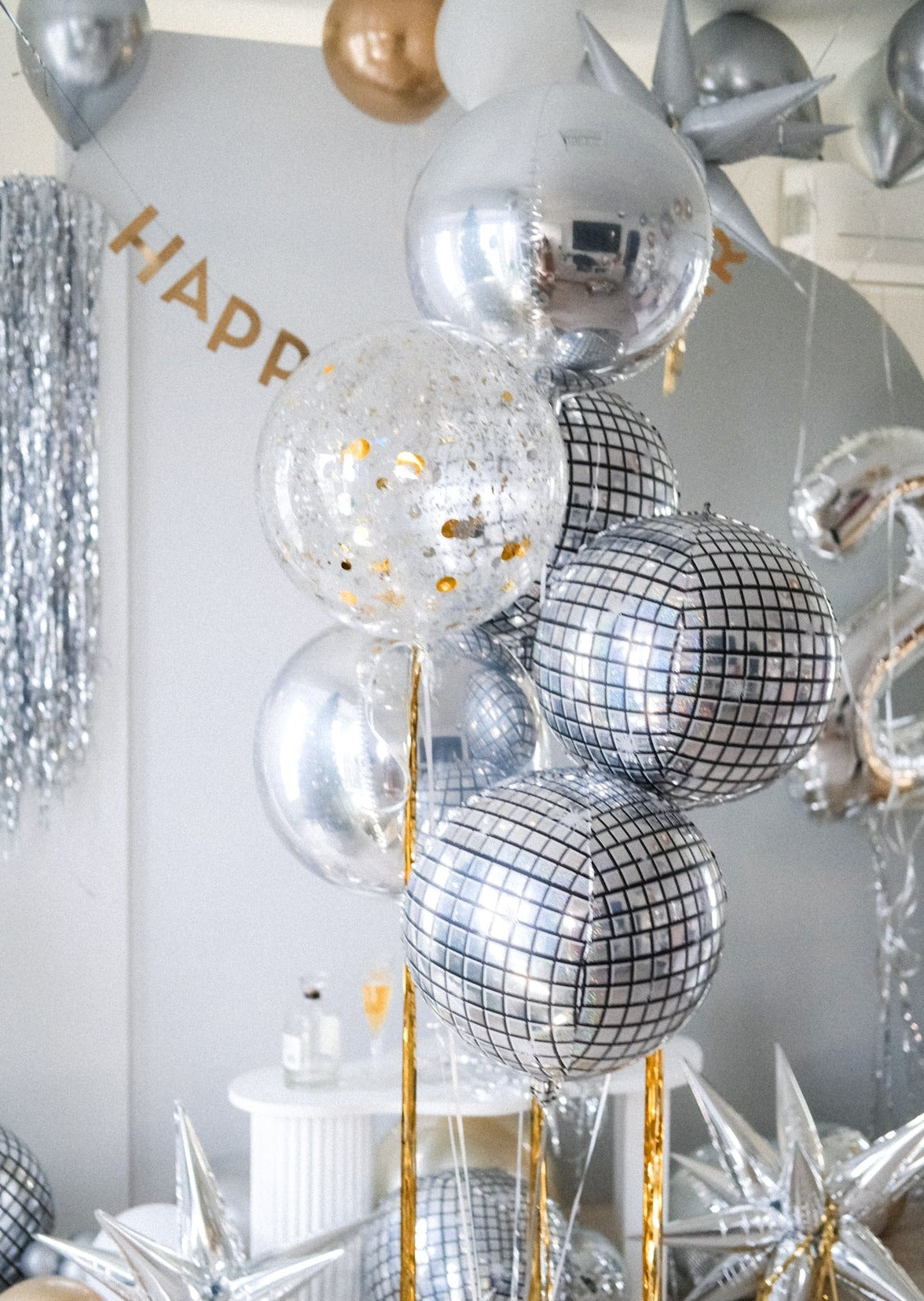 a set of round metallic balloons in silver, disco and confetti
