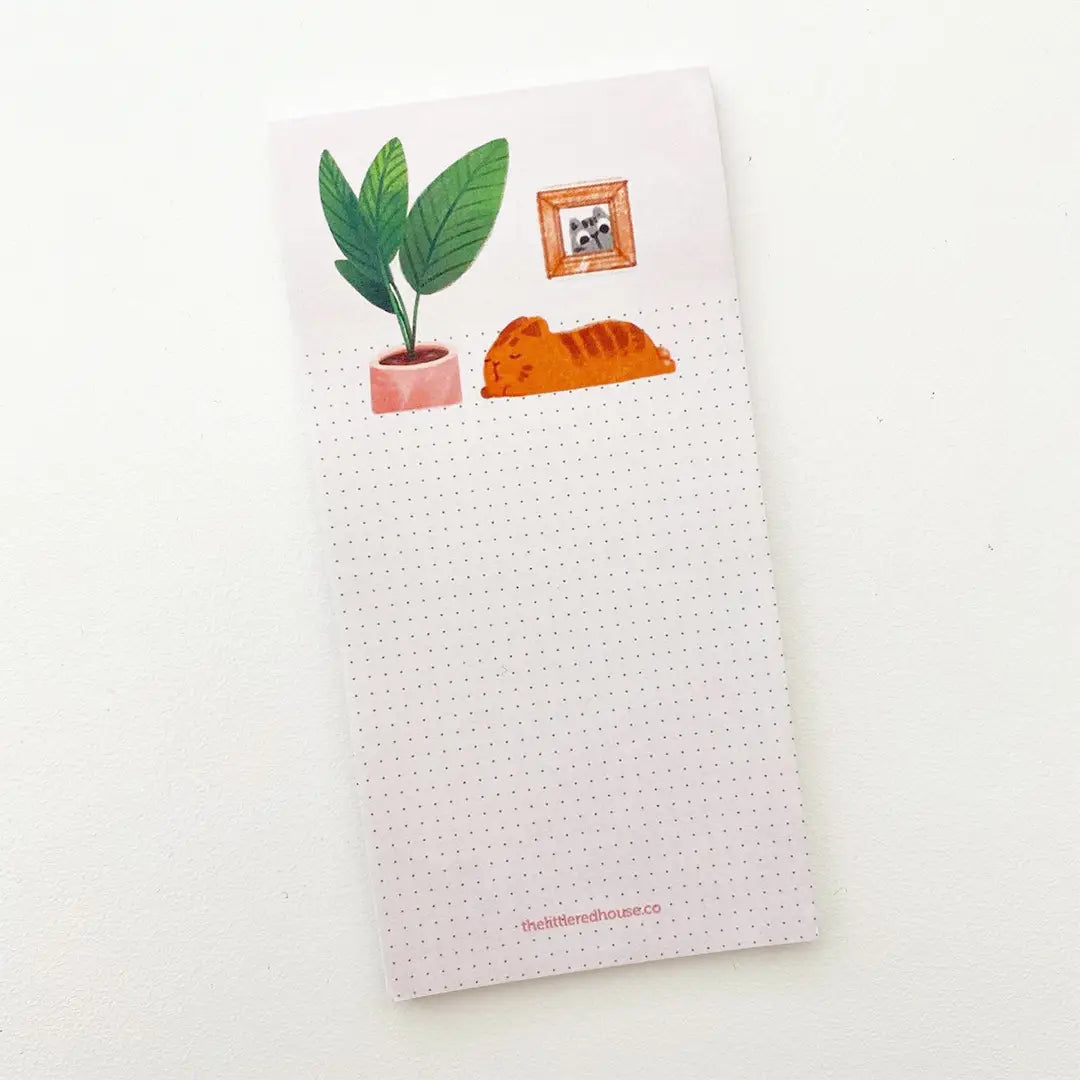 A sticky note with a dot grid format featuring an illustration of a napping cat and a potted plant on the cover.