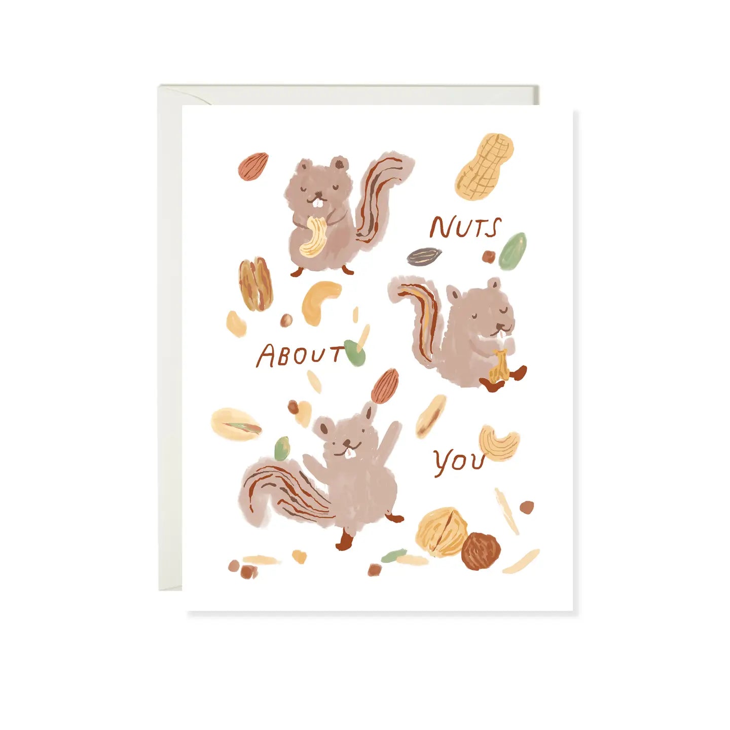 A greeting card with squirrels eating nuts and nuts spread around. Text reads "Nuts about you"
