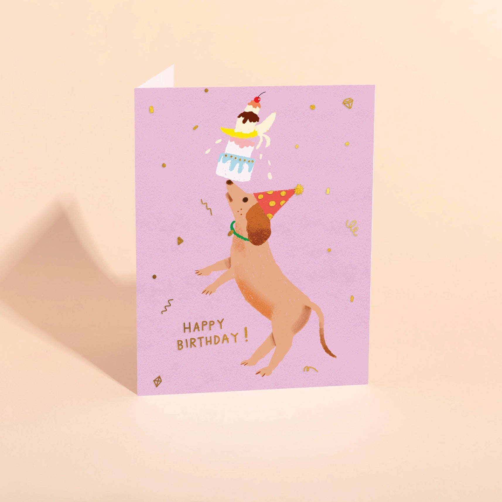 purple birthday card with dog balancing treats