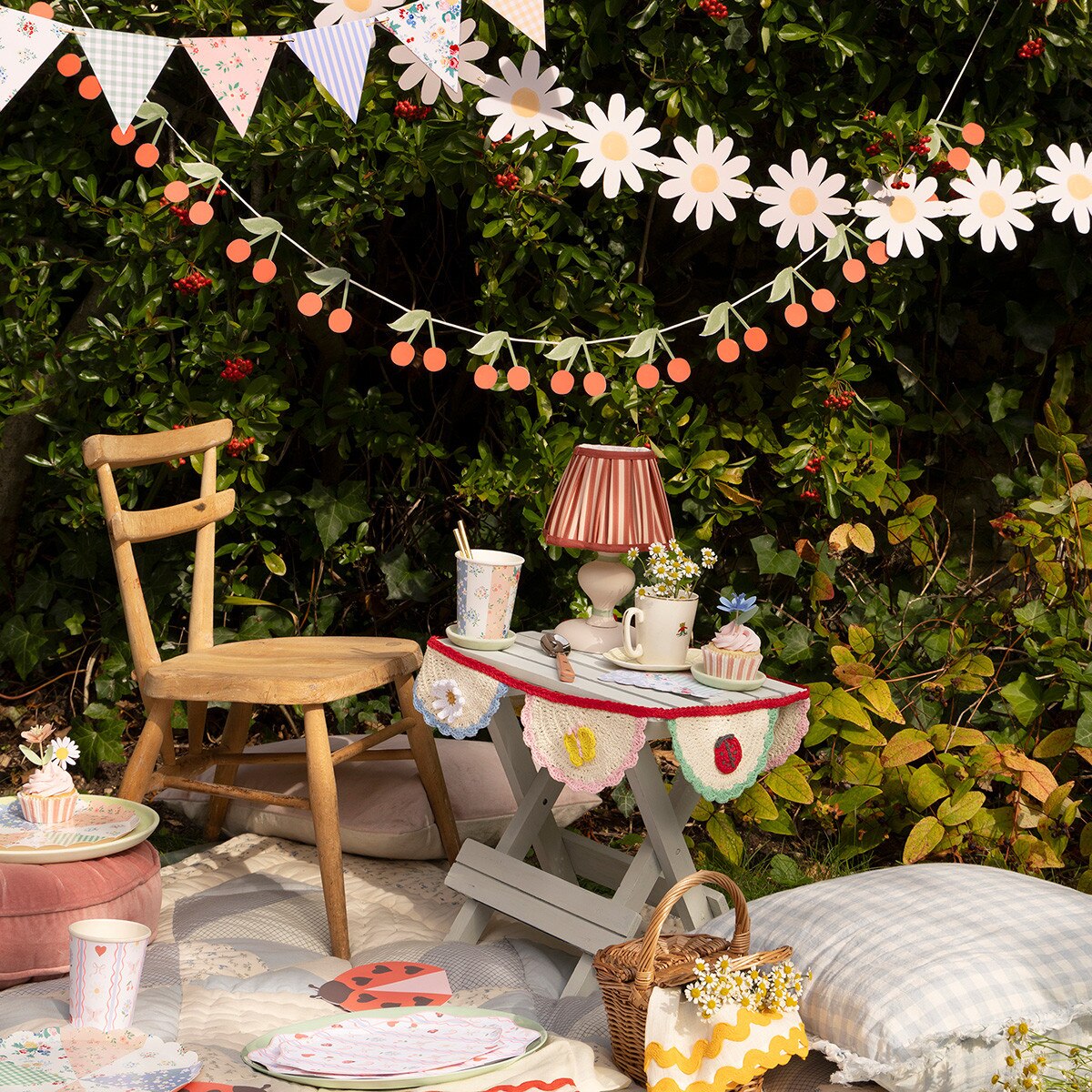 Outdoor setting with a small table, chair, and decorative banners in garden