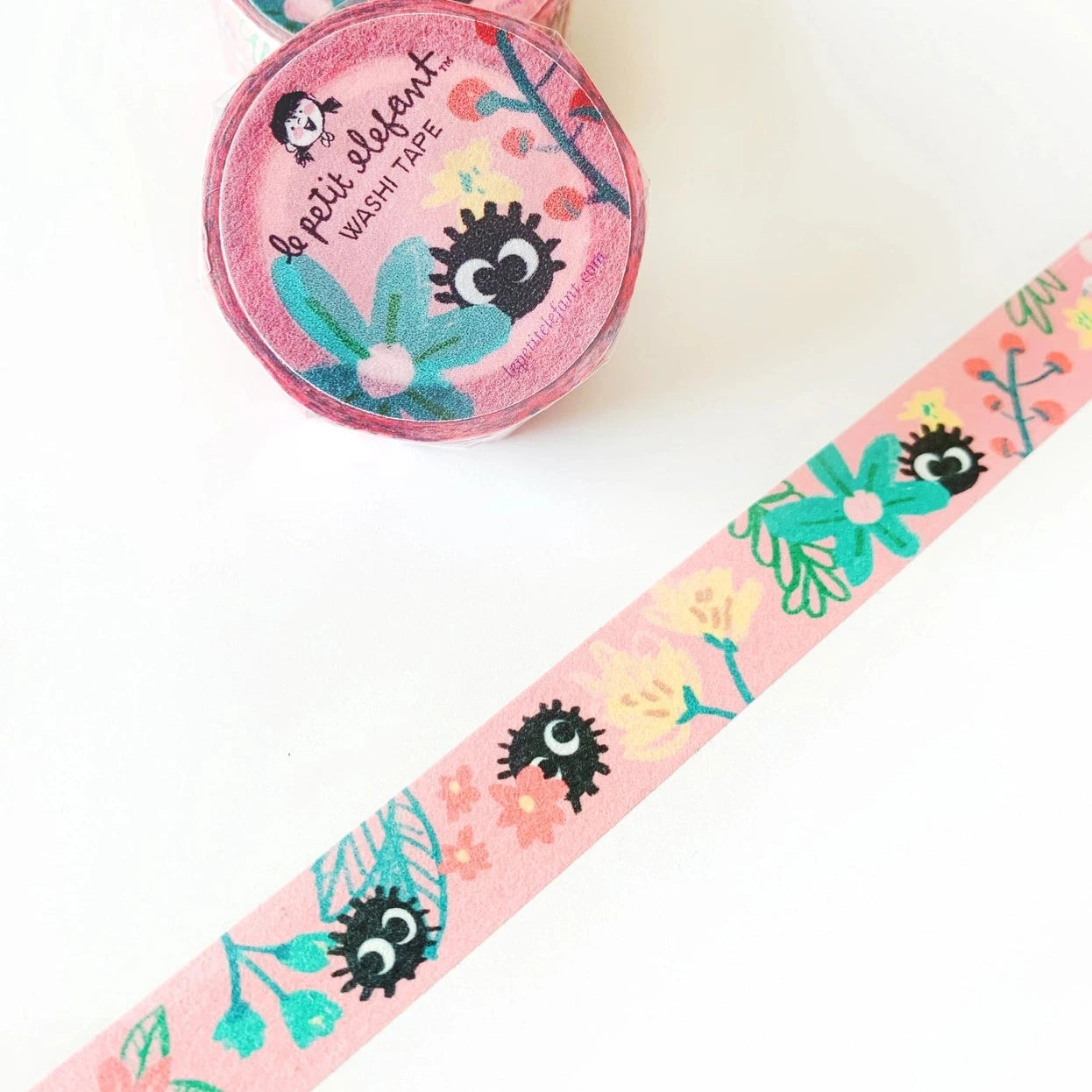 Pink washi tape roll with plants, flowers and black soot balls with eyes.