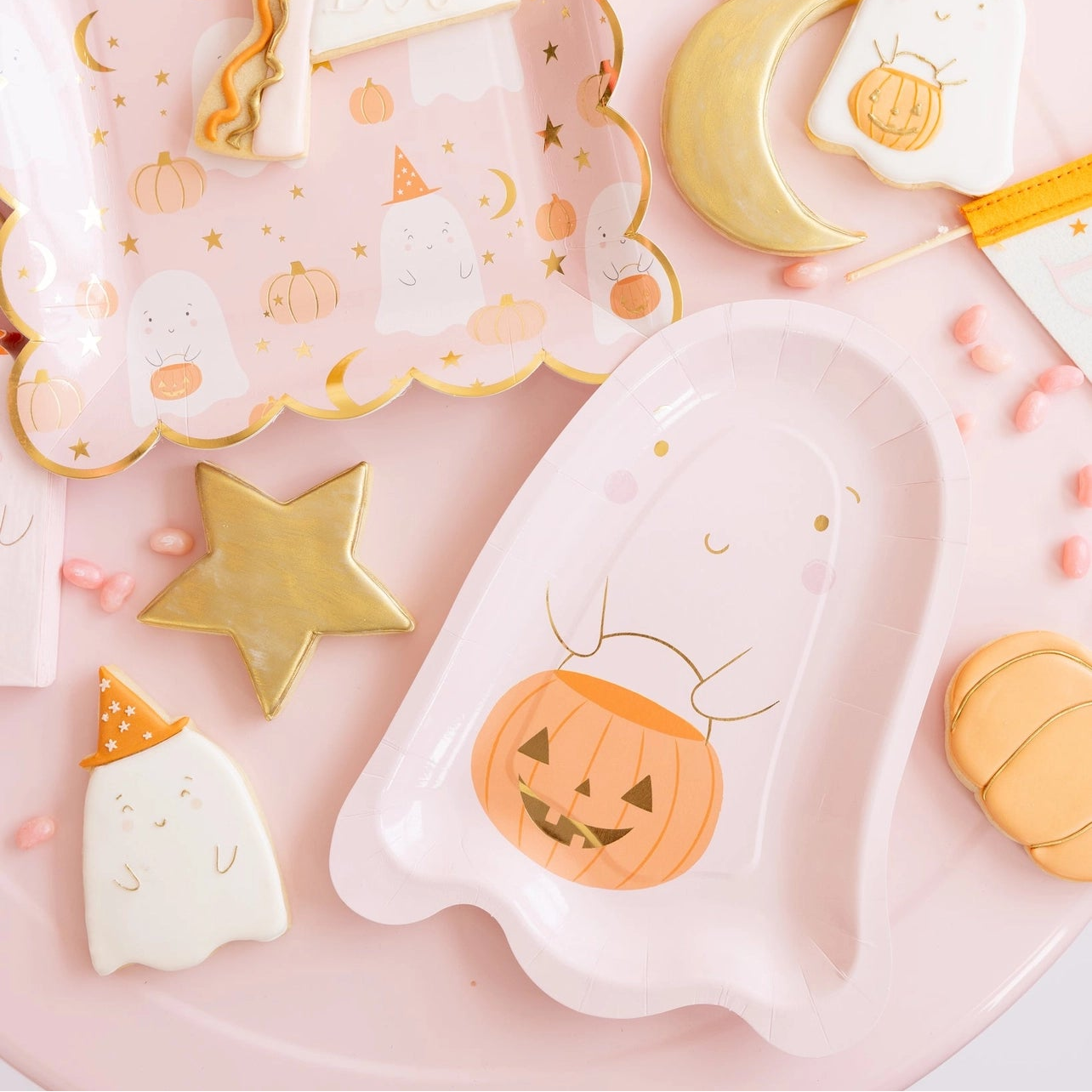 pink halloween tablescape with cookies and pink halloween plates