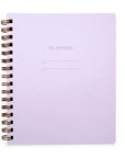 A closed planner in lilac color with a letterpressed cover, titled 'PLANNER' at the top, bound by a brass wire-o binding.