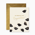 A greeting card with grad caps and gold text reading "so proud of you congratulations!"