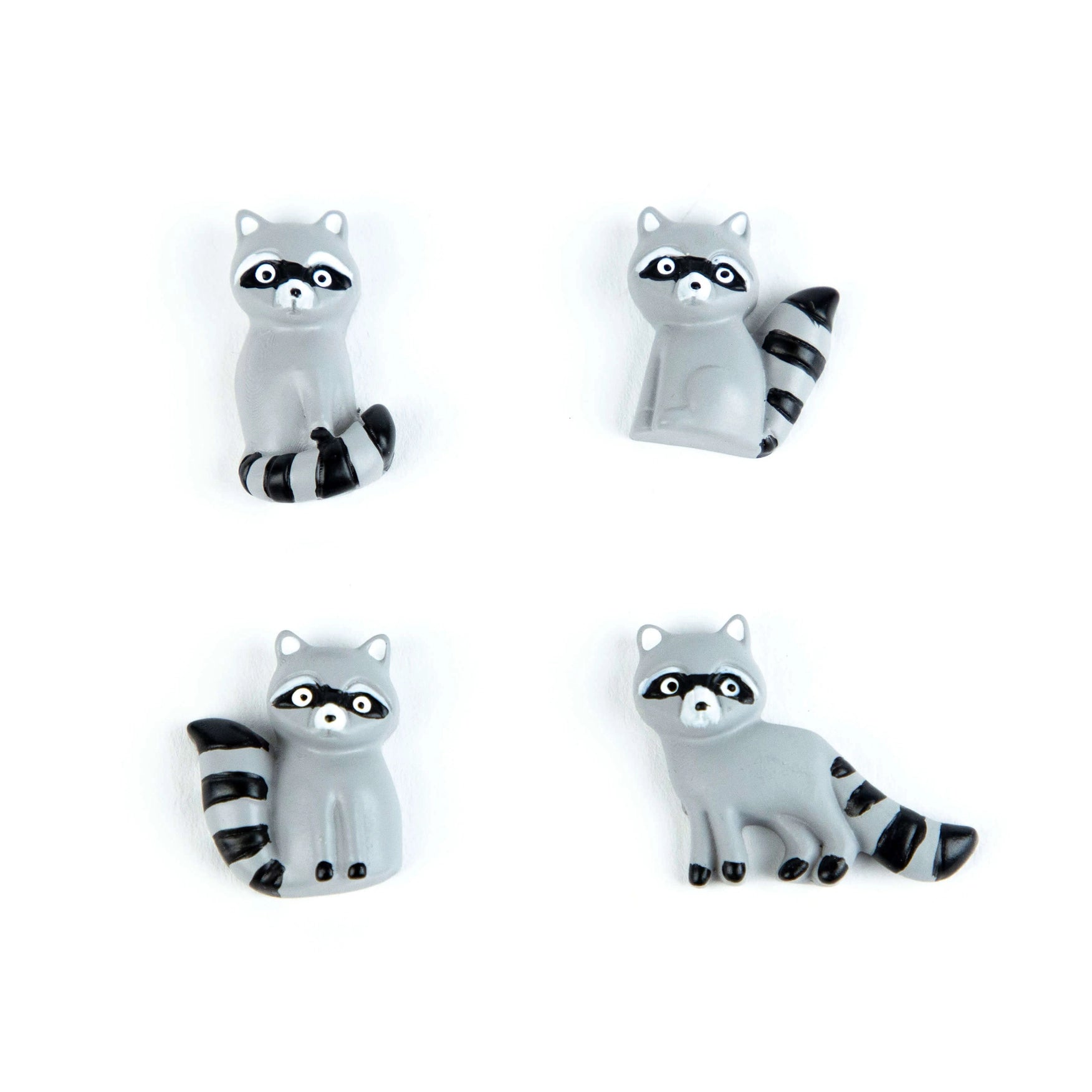Four raccoon figurines on a white background