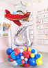 Decorative balloon arrangement with airplane and number '4' in a store setting