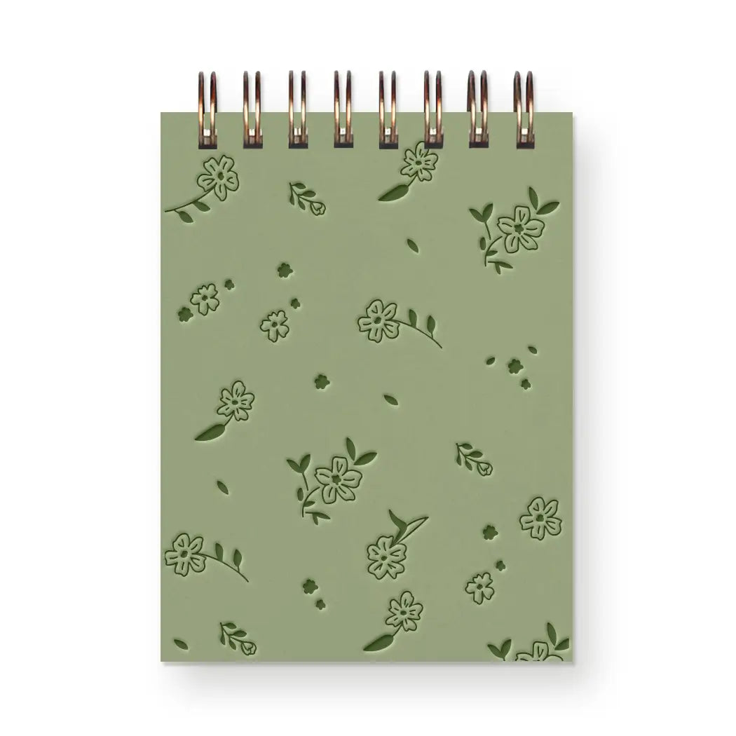 Green notebook with floral patterns on a white background