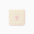 A folded cocktail napkin with pink and cream color and gold foil dots, featuring a scalloped edge and a small embroidered logo in the center.