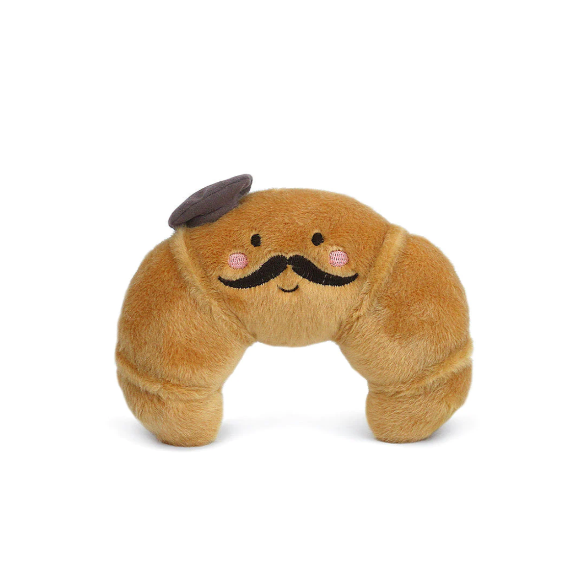 A plush toy resembling a croissant with a smiling face, wearing a beret and mustache, in a brown color.