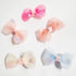 A set of five hair clips with pastel pink, blue, and yellow bows, each adorned with glitter and small decorative elements.