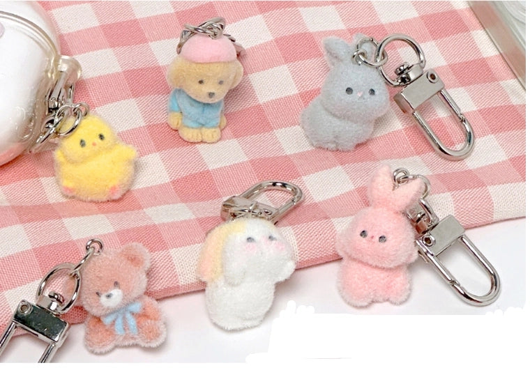 Plush keychains shaped like animals on a checkered fabric background