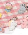 Plush keychains shaped like animals on a checkered fabric background