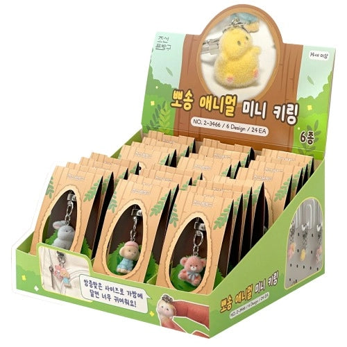 Display box of small animal keychains with a green background