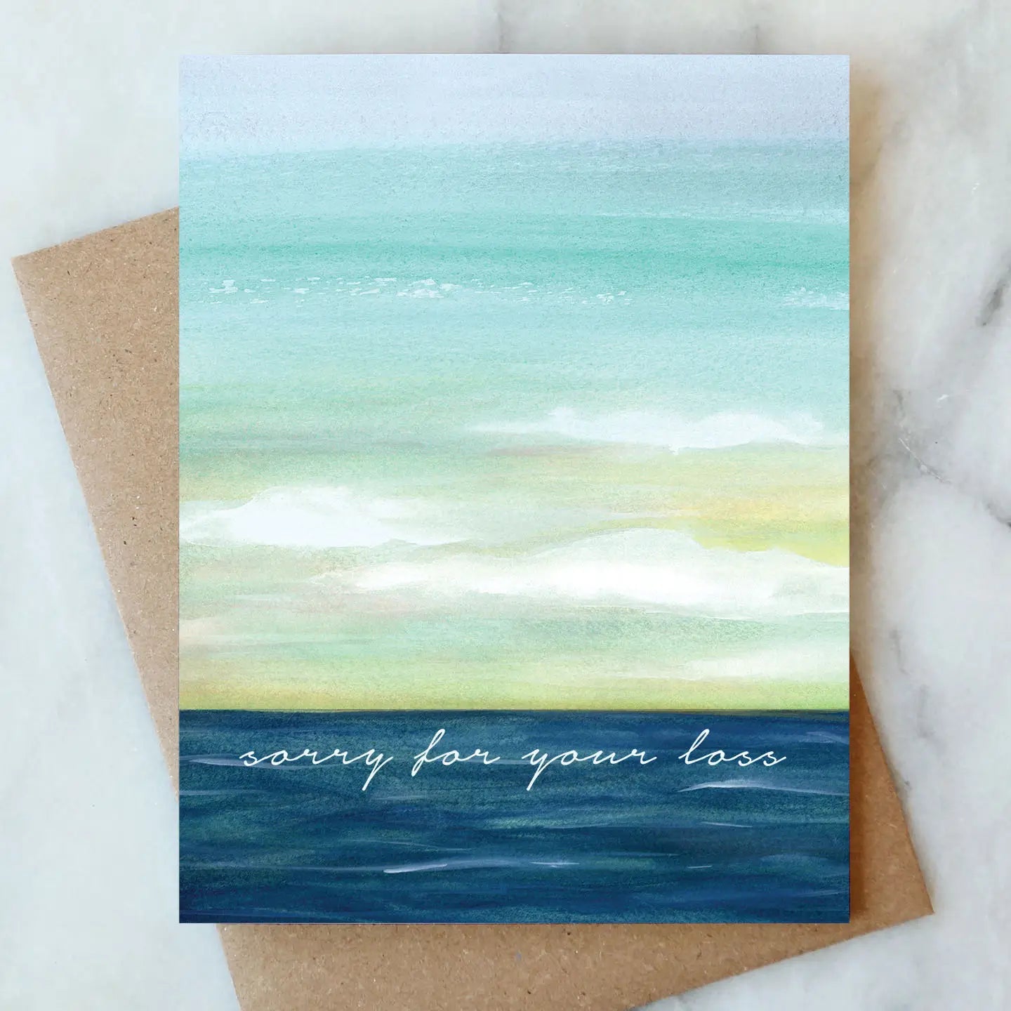 Greeting card with watercolor design and 'sorry for your loss' text on a marble surface.